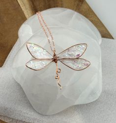 ❤️100% Handmade Copper Wire & UV epoxy Dragonfly Pendant Necklace with multiple color options.  This is a 100% Handmade Dragonfly pendant necklace designed, and made by me, Elle!  I make these Dragonflies using pure copper wire which I hand shape into each wing, even adding the veins within the wing depending on the colors chosen. After the Dragonfly sections are made I fill them with UV epoxy, adding natural Mica powder to change the colors.  The necklace pendant is about 3" wide and 1.5-1.75" long.  Large enough to be noticed, but not bulky. They are delicate looking but strong. Feel free to ask for any color, or ombre pattern on your earrings, or necklace. Shown is a clear with sparkle option, a iridescent pearl white with sparkle option, and a ocean ombre dragonfly. Feel free to ask fo Adjustable Wing-shaped Jewelry Gift, Adjustable Wing-shaped Jewelry For Gifts, Whimsical White Pendant Jewelry, Whimsical White Necklaces For Gifts, Whimsical White Necklace For Gift, Whimsical White Necklace Perfect For Gifts, White Dragonfly Jewelry Gift, Handmade Whimsical Butterfly Necklace, Whimsical Handmade Butterfly Necklace