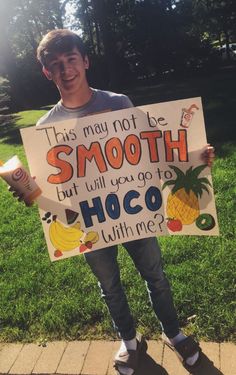 a boy holding a sign that says, this may not be smooth but will you go to hoco with me?