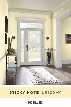 a living room with yellow walls and white trimmings on the door, carpeted floor