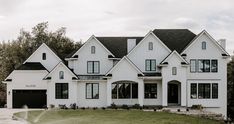 a large white house sitting on top of a lush green field