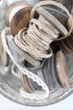 there are many different types of rope in the glass bowl on the table, including twine and buttons