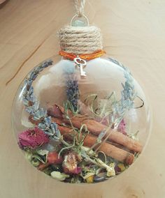 a glass ornament filled with flowers and cinnamons