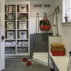 a dog's kennel with its door open and shoes on the floor in front of it