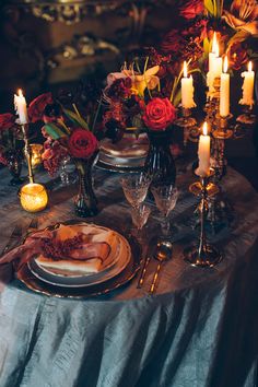 the table is set with candles, plates and other items for an elegant dinner party