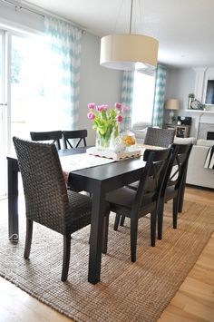 a dining room table and chairs with flowers in the center