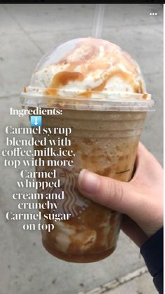 someone holding up a cup of iced coffee with whipped cream and caramel on top