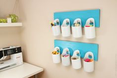 a sewing machine and some cups hanging on a wall next to a blue piece of wood