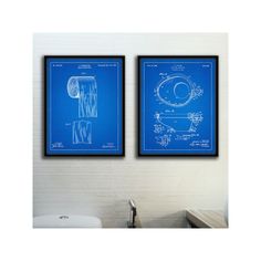 two framed blueprints of toilet paper on the wall above a sink in a bathroom