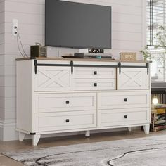 a white dresser with a flat screen tv on top