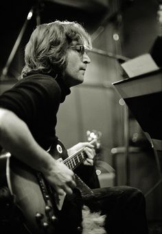 black and white photo of man playing guitar