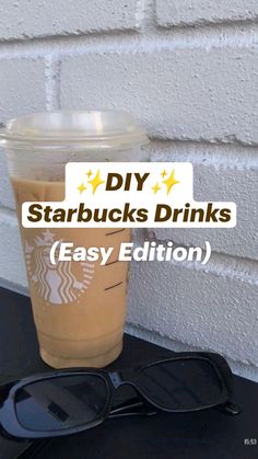 a starbucks drink sitting on top of a table next to sunglasses