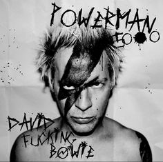 a black and white photo of a shirtless man with paint on his face, in front of a poster that says powerman booze