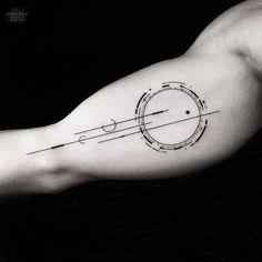 a man's arm with an arrow and circle tattoo on the left side of his arm