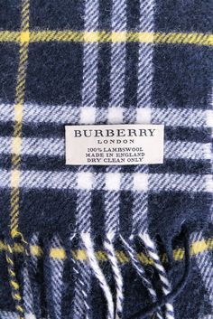 Stay stylish and cozy all winter long with this Burberry plaid lambswool scarf. In navy, white, and yellow, this scarf adds a pop of color to any outfit while the fringe trim adds a touch of fun. Perfect for layering over a timeless trench or adding a cute touch to your cold-weather look. Made in England 100% Lambswool Fringe hem Length 60" Width 12" Burberry Plaid, Burberry Scarf, Chunky Scarves, The Fringe, Yellow Plaid, Fringe Trim, Tartan Pattern, Scarfs, Navy White