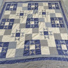 a blue and white quilt with stars on the top is sitting on a table cloth