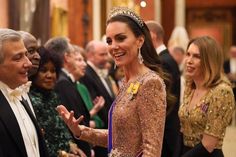 a woman wearing a tiara standing next to a man in a suit