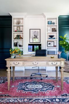 a home office with built in bookshelves, desk and rug on the floor