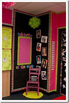 a classroom decorated in bright colors with pictures on the wall and pink chair next to it