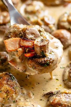 a spoon full of mushrooms and carrots being lifted from a skillet