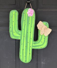 a green cactus shaped door hanger with a pink flower on it's side