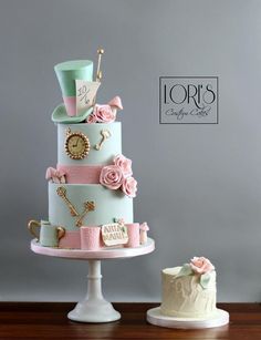 there is a three tiered cake with pink and blue decorations on the top layer