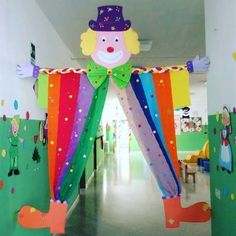 a hallway decorated with colorful drapes and paper cutouts on the walls, including a large clown head