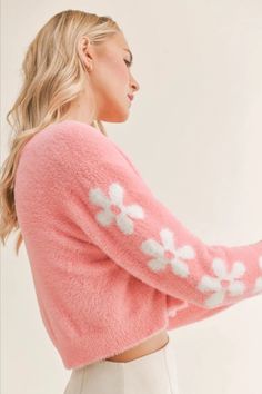 This soft and sweet cropped cardigan in a bold barbie pink features covered buttons and a white floral pattern down the sleeves. Pair this adorable cardigan with a jeans for a more casual look or dress it up for a date night with a white skirt and heels. Chic Pink Cropped Sweater For Winter, Cute Pink Soft Knit Cardigan, Trendy Pink Soft Knit Cardigan, Feminine Soft Knit Sweater For Spring, Trendy Pink Fitted Cropped Sweater, Trendy Fitted Pink Cropped Sweater, Pink Feminine Sweater For Loungewear, Pink Soft Knit Cropped Sweater For Fall, Cozy Pink Long Sleeve Cropped Sweater