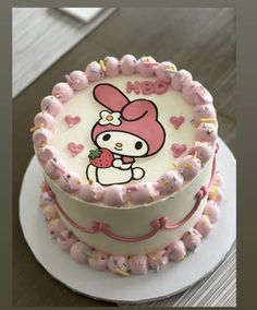 a hello kitty cake with pink frosting and sprinkles on the top