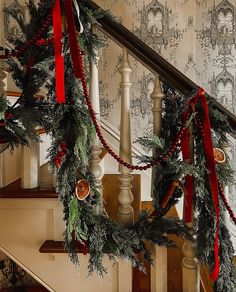 christmas garland on banisters with red bows and bells hanging from the banister