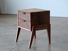 a small wooden table with two drawers on one side and an open drawer on the other