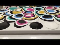 a white table topped with lots of black and pink circles on top of each other