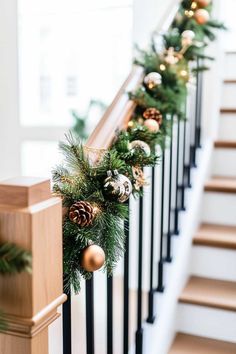 christmas garland with pine cones and ornaments on the banister