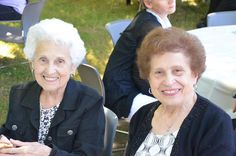 two older women sitting next to each other at a table