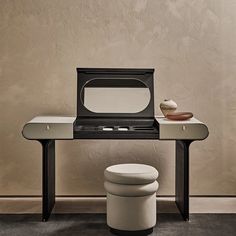 a white toilet sitting in front of a mirror on top of a wooden table next to a stool