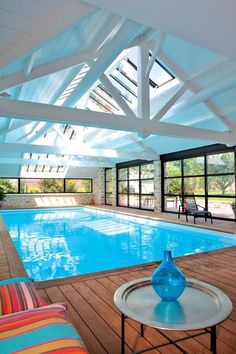 an indoor swimming pool surrounded by wooden floors