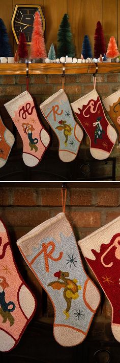 several christmas stockings hanging from hooks in front of a fireplace