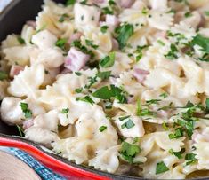 a skillet filled with macaroni and cheese covered in parsley