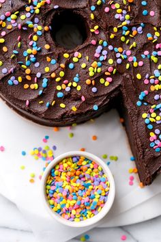 a chocolate cake with sprinkles and a small bowl