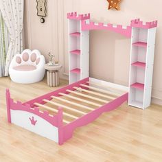 a child's bedroom with a pink and white castle bed frame, bookshelf and toys on the floor