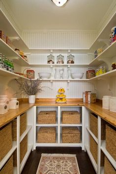 an image of a kitchen with white cabinets and wood floors, including baskets on the shelves