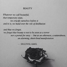 a black rose sitting on top of a piece of paper with words written below it