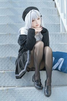 a woman with white hair and black stockings sitting on some steps next to a blue bag