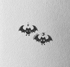 two bats are flying in the air with stars and moon on their wings, one is black