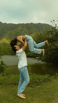 a man is holding up a woman in the air