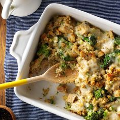 a casserole dish with chicken and broccoli in it on a blue towel