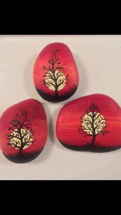 three painted rocks with trees on them