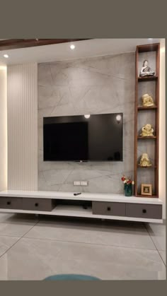 an entertainment center with a flat screen tv mounted on the wall and shelving unit