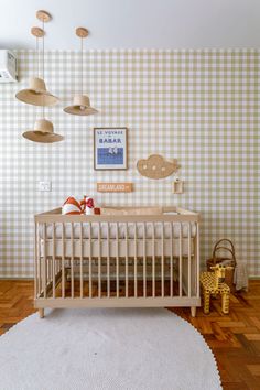 a baby's room with checkered wallpaper and wooden furniture, including a crib