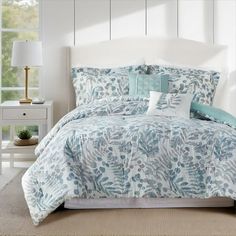 a bed with blue and white comforters in a room