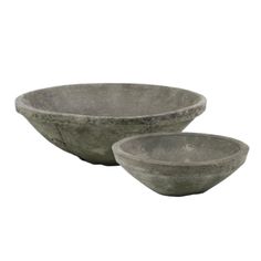 two stone bowls sitting next to each other